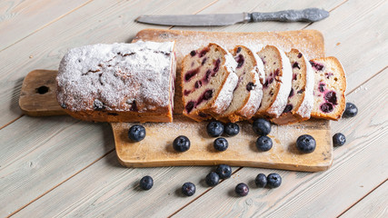 Homemade vanilla cupcake with fresh blueberries on a wooden background. Banner