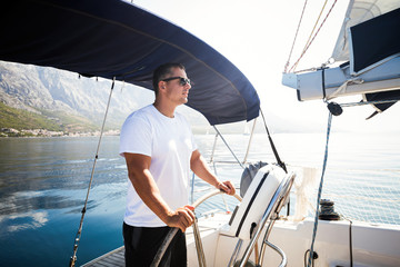 Happy smiling man sailing with his yacht