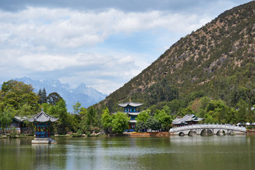 Naklejka premium Landscape of Black Dragon Pool and snow mountain in background at Lijiang, Yunnan, China.