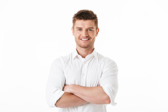 Portrait of a happy young man standing with arms folded
