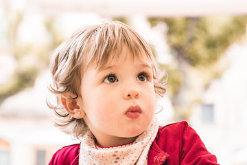 Portrait of a lovely little blonde girl outdoors