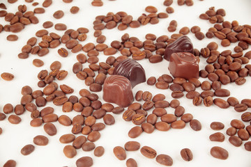 grain black coffee and chocolate candy on a white background