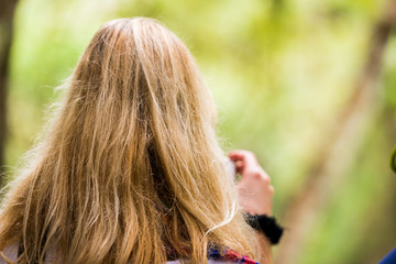 Blonde girl in the woods close-up, Luang Prabang, Laos. Copy space for text. Back view.