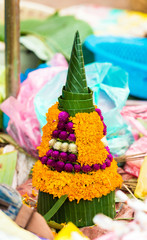 Sale of sacrificial offerings from banana leaves and flowers, Luang Prabang, Laos. Close-up. Vertical.