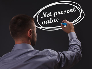 The concept of business, technology, the Internet and the network. Young businessman showing inscription: Net present value