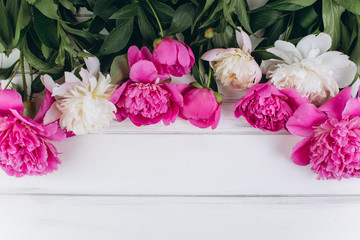 Pink and white peonies on a wooden background. Copy space and flat lay.