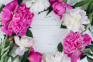 Pink and white peonies on a wooden background. Copy space and flat lay.