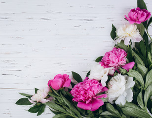 Pink and white peonies on a wooden background. Copy space and flat lay.