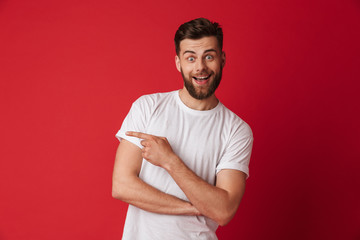 Handsome young emotional man pointing. Looking camera.