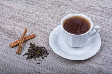 A cup of tea with cinnamon on a table