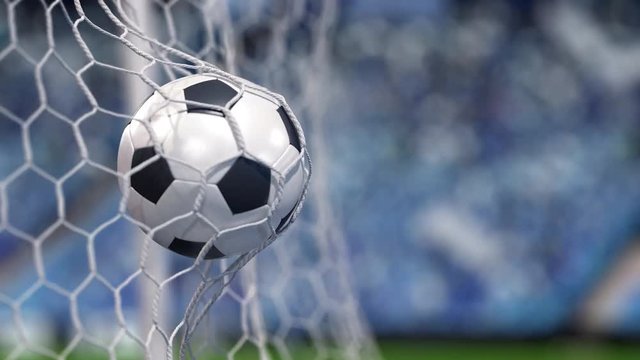 Soccer ball flies into the net on a stadium. In slow motion