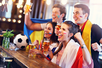 Group of friends watching soccer in pub