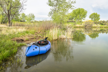 Fototapeta na wymiar packraft with a paddle on lake shore