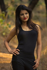 Stylish and beautiful woman wearing black top and leggings smiling