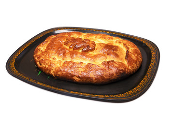 Traditional russian closed pie with cabbage on a tray, isolated on white background