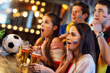 Group of friends watching soccer in pub