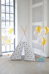 Decorations for birthday party in gold style. A lot of balloons gold colors. twins party.  wigwam party.  © avikki