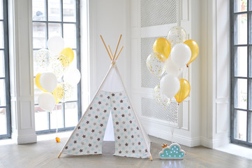 Decorations for birthday party in gold style. A lot of balloons gold colors. twins party.  wigwam party.  © avikki