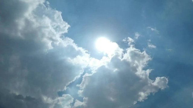 Timelapse Footage of Clear Blue Sky with White Clouds and Sunlight Shining Through in Full HD resolution.