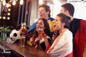 Group of friends watching soccer in pub