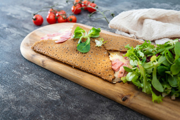 Black wheat and wheat galette topped with cooked ham and emmental cheese