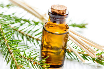 cosmetic spruce oil in bottles with fur branches on white table 