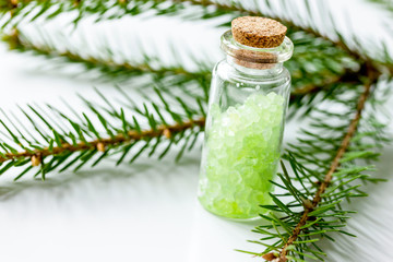 cosmetic spruce salt in bottles with fur branches on white table