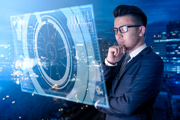 The abstract image of business man looking to the hologram and blurred cityscape is backdrop. the...