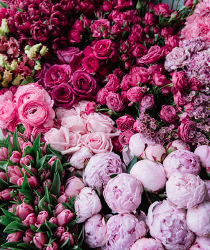 Fototapeta Beautiful fresh blossoming flowers texture at the florist shop in ombre color from magenta pink to pastel pink: ranunculus, peonies, roses, tulips, carnations, top view, flat lay 