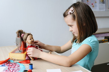 The girl dressing the doll.