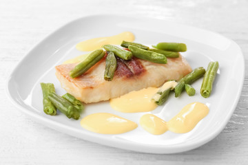 Plate with tasty fish and green beans, closeup