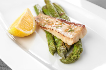 Plate with tasty fish and asparagus, closeup