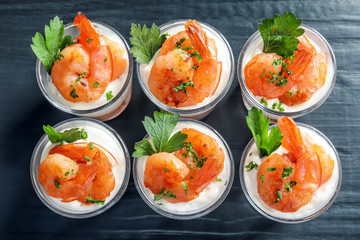 Glasses with fried shrimps and sauce on wooden background