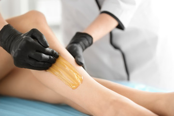 Woman getting wax epilation in salon