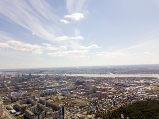 Fototapeta premium Clouds in the blue sky wih buildings under them at Novosibirsk, Russia. Streets and skyline.