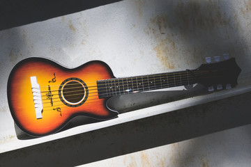 Wooden acoustic guitar displayed on an urban seat