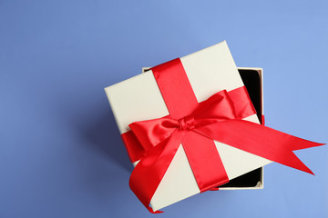 Beautifully decorated gift box on color background, top view