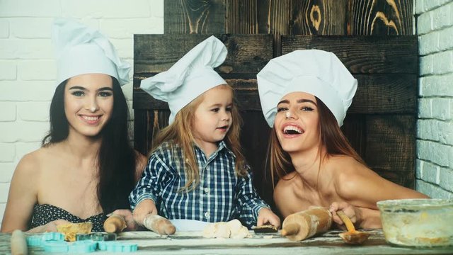 Lesbian Couple Cooking With Their Adopted Child. Sisters Cooking With Their Younger Brother