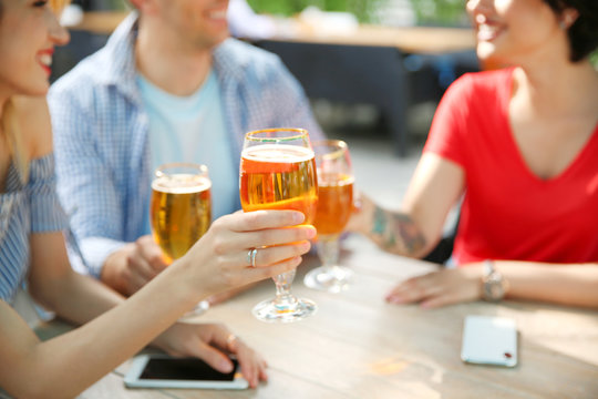 Young people with glasses of cold beer at table