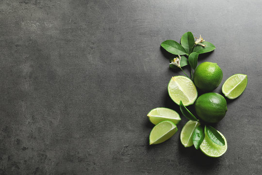 Composition with fresh ripe limes on gray background, top view