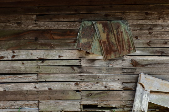 Sheet metal and bed frame hanging from a barn wall.