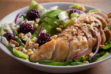 Kiwi, avocado, blackberry, spinach, walnuts salad with chicken and feta cheese. Healthy diet food bowl. horizontal