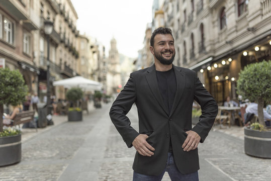 Posing bearded mid adult elegant suit man in european street