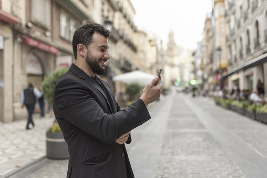 Man in the city with smartphone looking messages