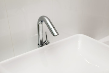 Element of bathroom interior. New wash basin, white sink and tile.