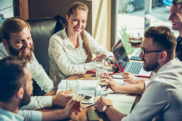 Young cheerful people smile and gesture while relaxing in pub.