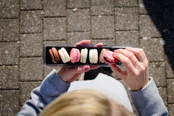 topshot of female hands holding assorted macarons 