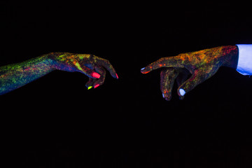 concept of connecting hands creative shooting in neon light male and female palms together stretch...