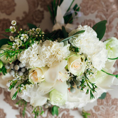 close-up of wedding bouquet with white roses lying on a chair