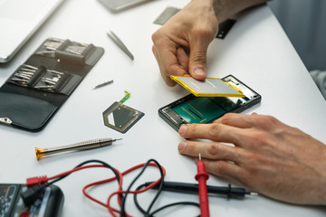 technician installing new battery in phone